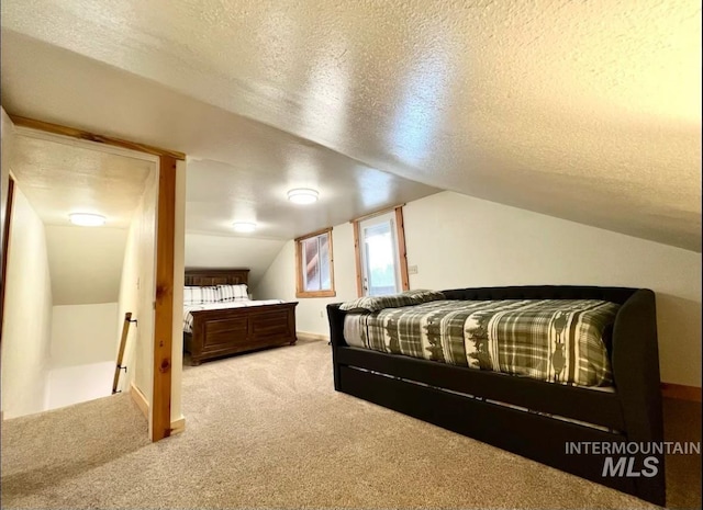 bedroom featuring carpet flooring, a textured ceiling, and lofted ceiling