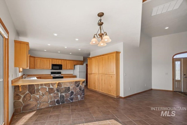 kitchen with black microwave, range with electric stovetop, freestanding refrigerator, light countertops, and a sink