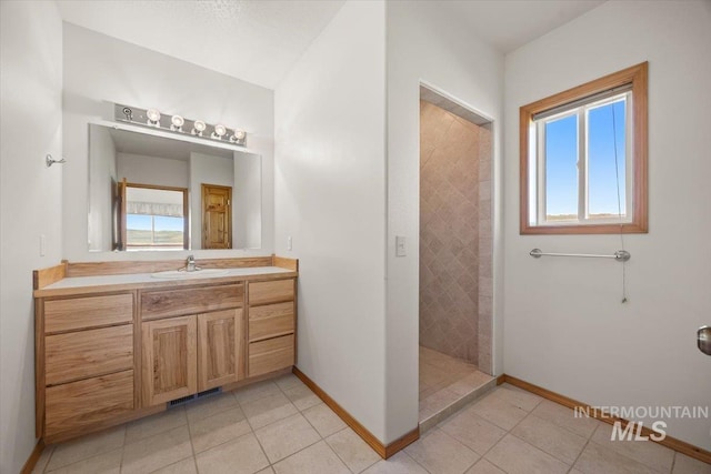 bathroom featuring plenty of natural light, tile patterned floors, walk in shower, and baseboards