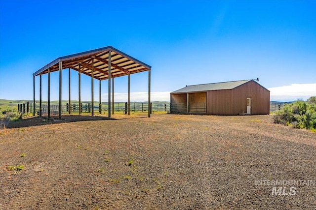 view of outbuilding featuring an exterior structure, a detached carport, an outdoor structure, and dirt driveway