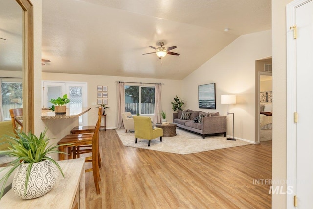 living room featuring lofted ceiling, hardwood / wood-style floors, and ceiling fan