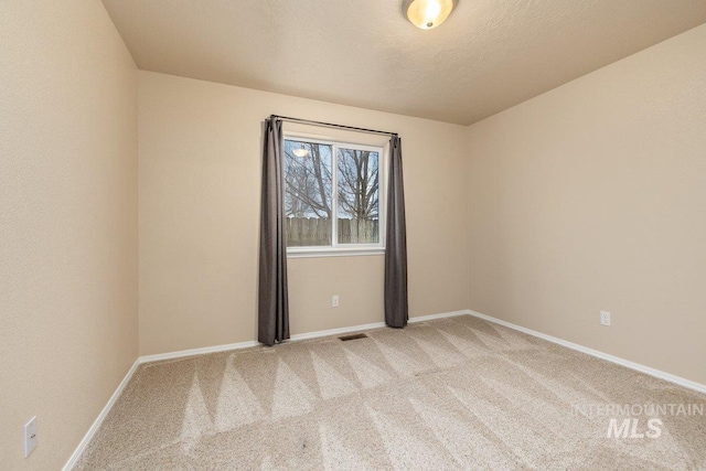 empty room featuring light colored carpet and a textured ceiling