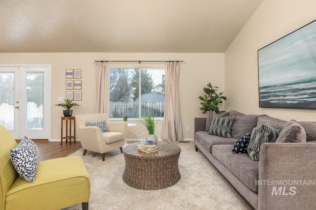 living room featuring a textured ceiling, light hardwood / wood-style floors, and french doors