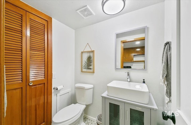 14 Cougar Ln, Boise, ID 83716 - bathroom with toilet, vanity, baseboards, and a closet