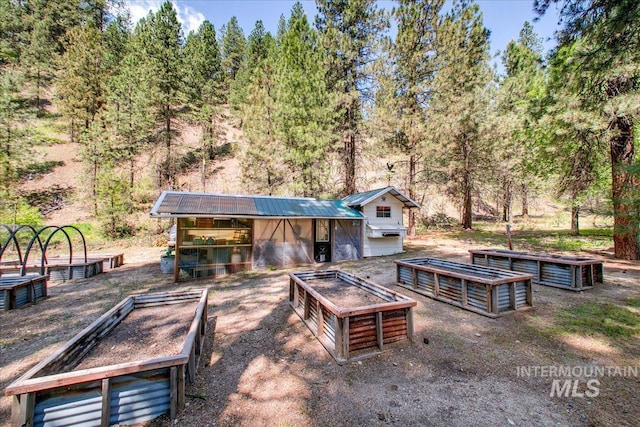 14 Cougar Ln, Boise, ID 83716 - back of house featuring a vegetable garden, metal roof, and an outdoor structure