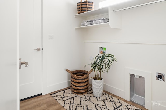 laundry area with laundry area, light wood-style flooring, baseboards, and hookup for an electric dryer