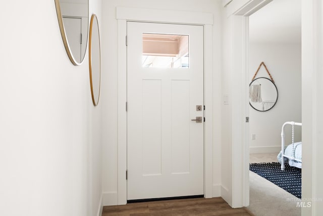 foyer entrance featuring dark wood-style floors and baseboards