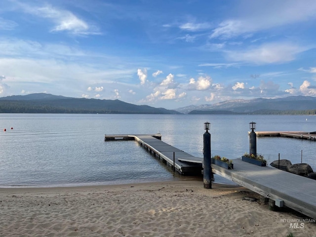 dock area featuring a water and mountain view and a view of the beach