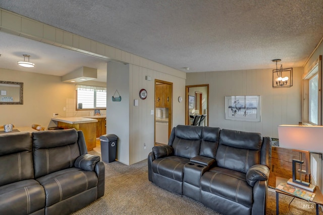 living room featuring a notable chandelier, a textured ceiling, and carpet floors