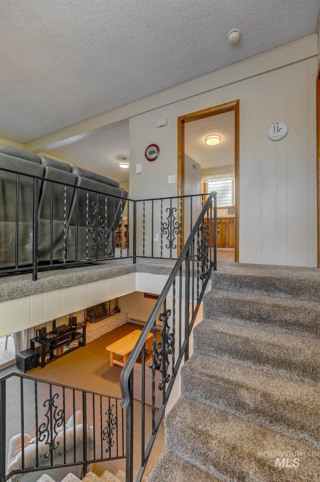 staircase with a textured ceiling and carpet