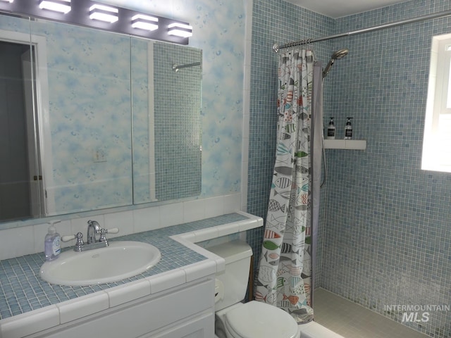 bathroom with curtained shower, toilet, and vanity