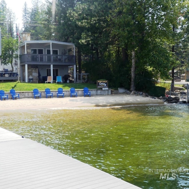 view of dock featuring a water view and a yard