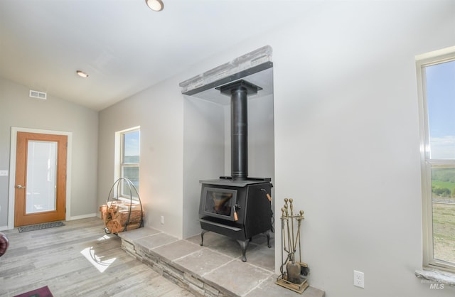 1190 Devils Elbow Rd, Weiser, ID 83672 - living room featuring plenty of natural light, wood finished floors, a wood stove, vaulted ceiling, and baseboards