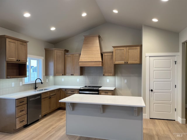 kitchen with premium range hood, sink, dishwasher, stainless steel stove, and a kitchen island