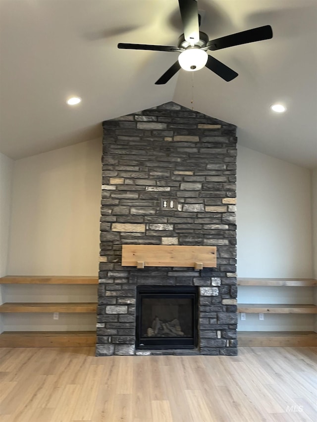 room details with hardwood / wood-style flooring, a stone fireplace, and ceiling fan