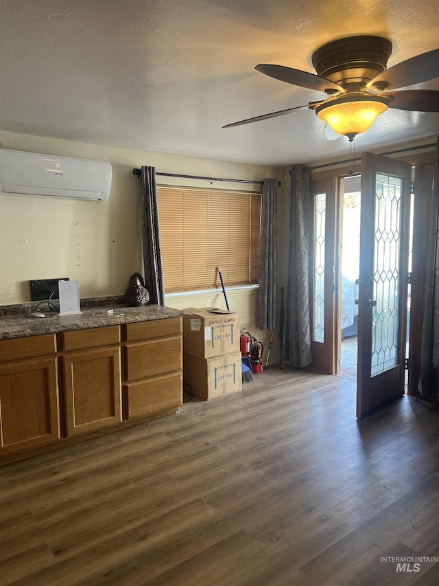 58438 Mansford Ave, Murphy Hot Springs, ID 83302 - kitchen with ceiling fan, dark wood finished floors, an AC wall unit, french doors, and brown cabinetry
