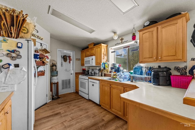 kitchen with light hardwood / wood-style flooring, white appliances, vaulted ceiling, and a textured ceiling