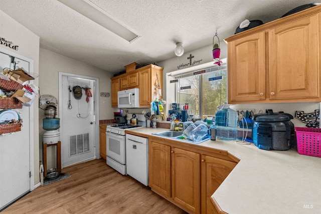 kitchen featuring light hardwood / wood-style floors, white appliances, vaulted ceiling, and a textured ceiling