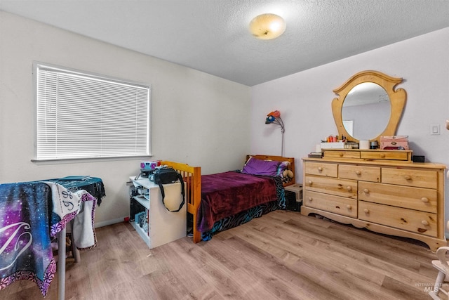bedroom featuring light hardwood / wood-style flooring and a textured ceiling