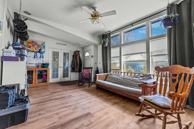 sitting room featuring french doors, ceiling fan, vaulted ceiling, and light wood-type flooring