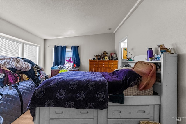 bedroom featuring light hardwood / wood-style floors and a textured ceiling