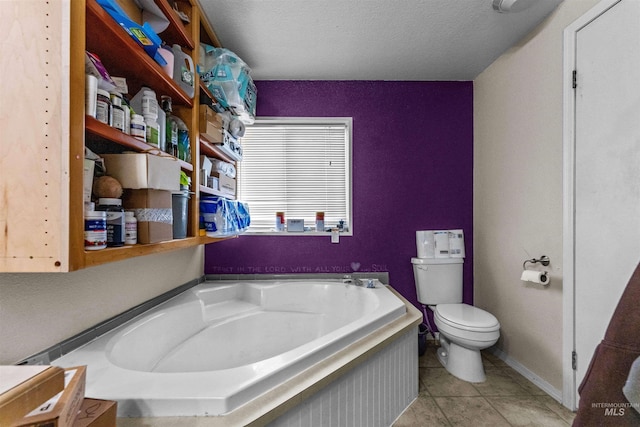 bathroom featuring a textured ceiling, tile floors, toilet, and a bath to relax in