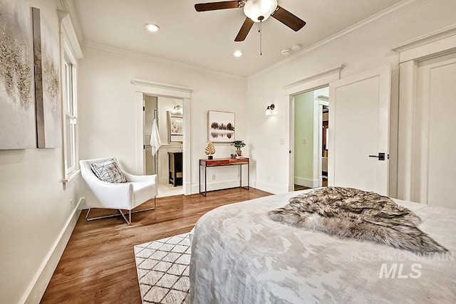 bedroom with recessed lighting, wood finished floors, baseboards, and ornamental molding