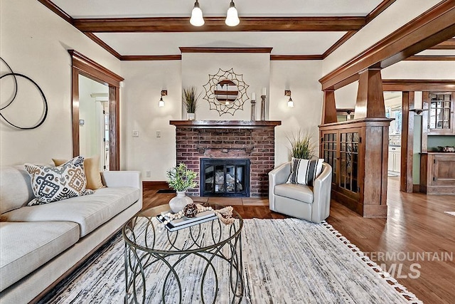 living room with beam ceiling, ornamental molding, wood finished floors, a fireplace, and baseboards