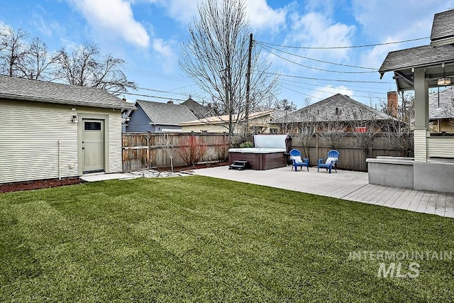 view of yard with a patio, a fenced backyard, and a hot tub