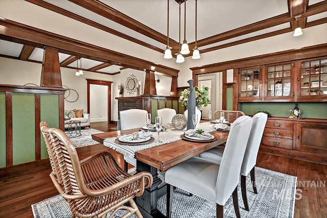 dining space featuring dark wood finished floors, beam ceiling, and crown molding