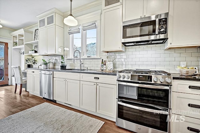 kitchen featuring a sink, open shelves, dark countertops, appliances with stainless steel finishes, and dark wood-style flooring