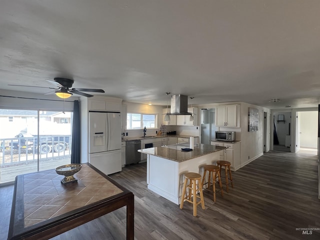 kitchen featuring stainless steel appliances, dark wood-style flooring, a sink, a kitchen island, and island exhaust hood