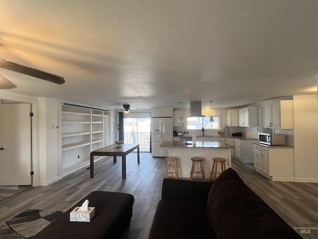 living area with a ceiling fan and dark wood-style flooring