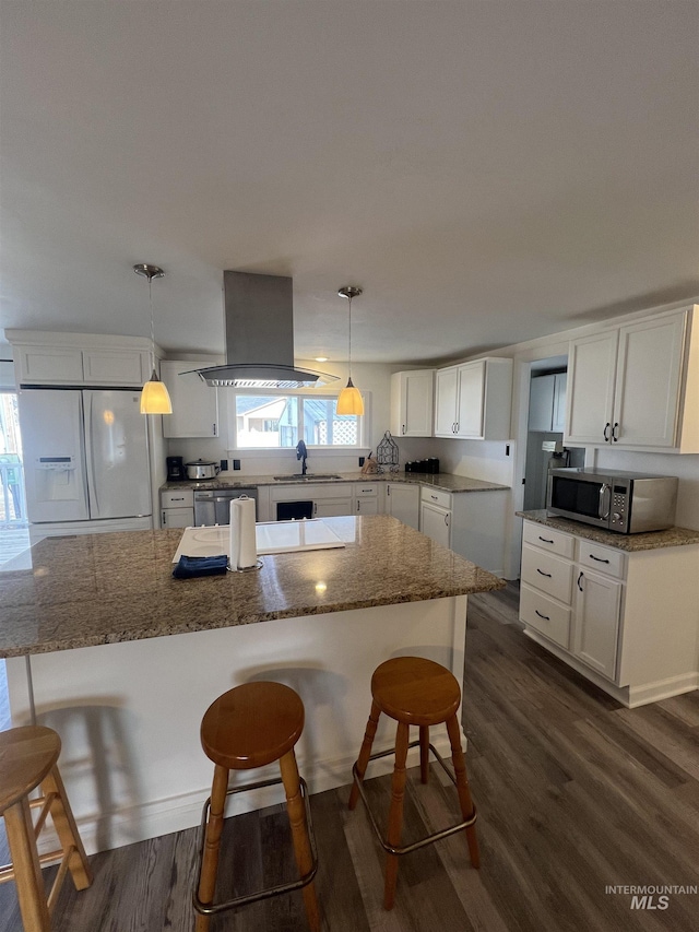 kitchen featuring island range hood, white cabinetry, dark wood-style floors, white fridge with ice dispenser, and stainless steel microwave