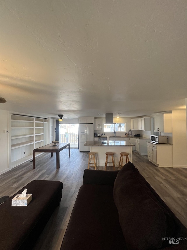 living room featuring dark wood finished floors and ceiling fan