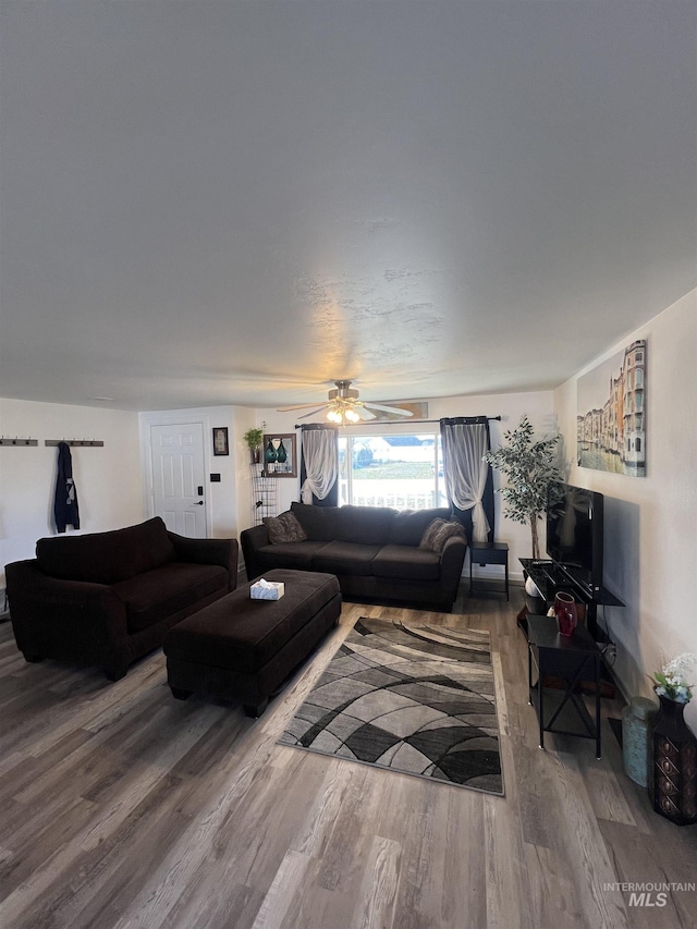 living area with ceiling fan and wood finished floors