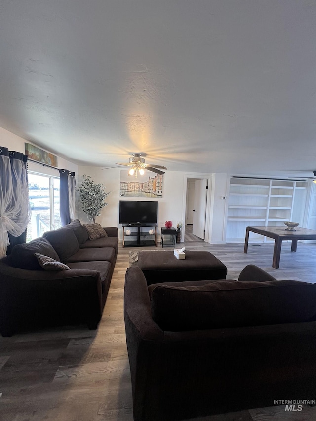 living area featuring wood finished floors and a ceiling fan