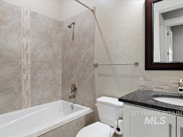 full bathroom with tiled shower / bath combo, vanity, and toilet