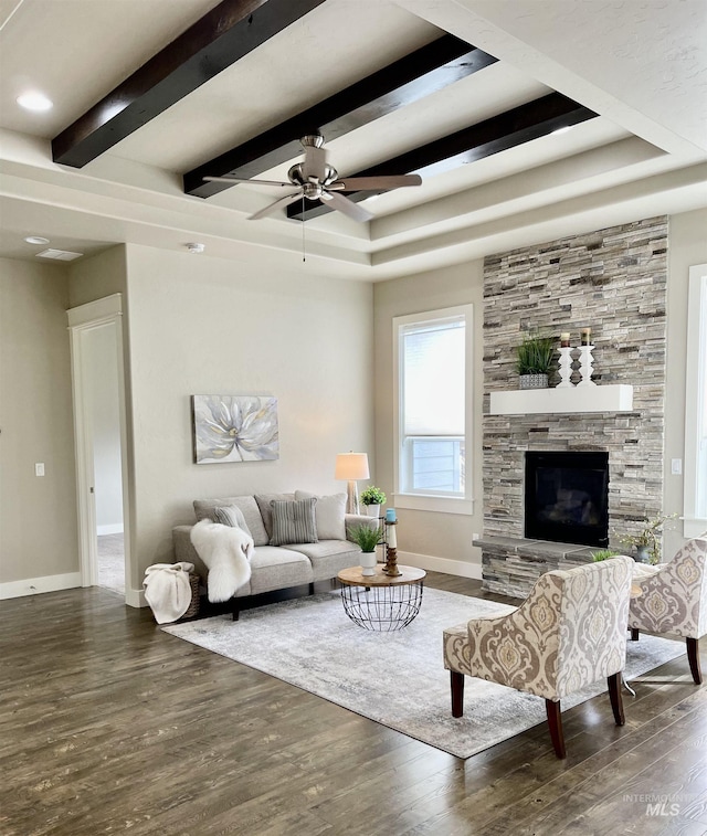 living room featuring dark hardwood / wood-style flooring, a tray ceiling, and beam ceiling