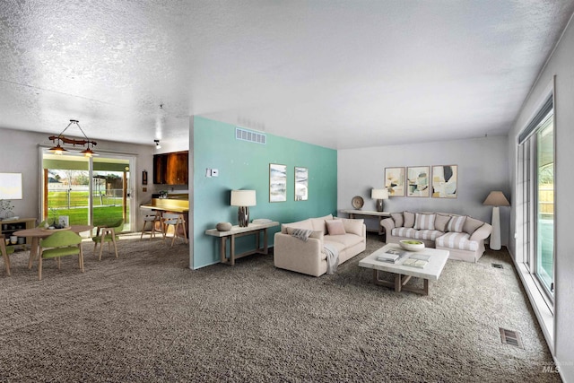 living room featuring a textured ceiling and dark colored carpet