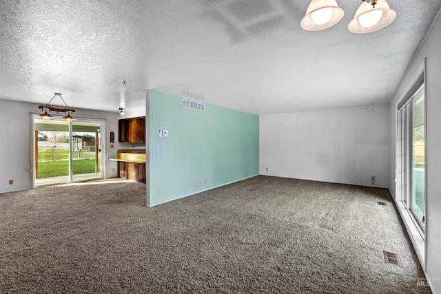 unfurnished living room with a textured ceiling and carpet flooring