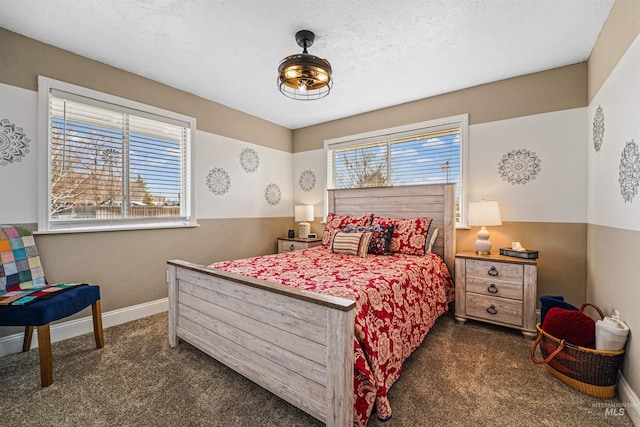 bedroom with baseboards, dark carpet, and a textured ceiling