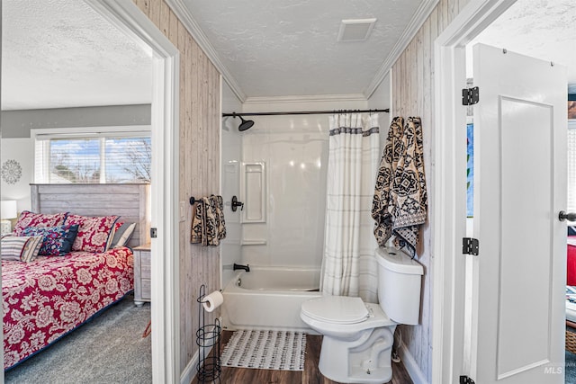 ensuite bathroom with a textured ceiling, toilet, shower / tub combo, visible vents, and ornamental molding