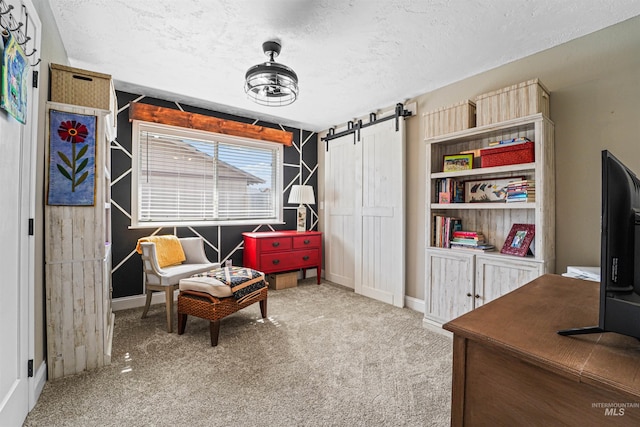 living area featuring carpet, a textured ceiling, and a barn door