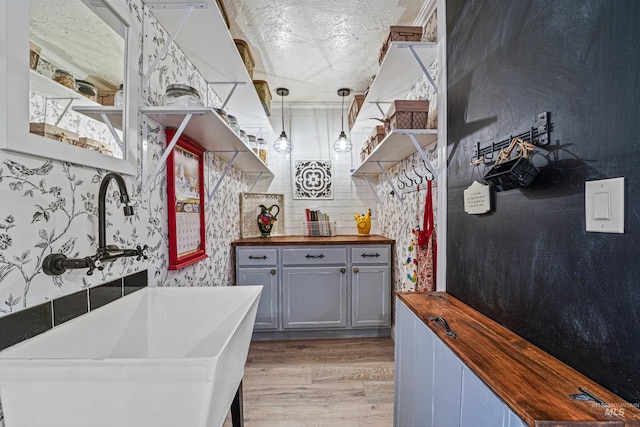 kitchen featuring gray cabinetry, wooden counters, open shelves, and light wood-style floors