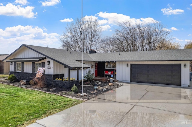 view of front of property with driveway, a chimney, roof with shingles, an attached garage, and a front lawn