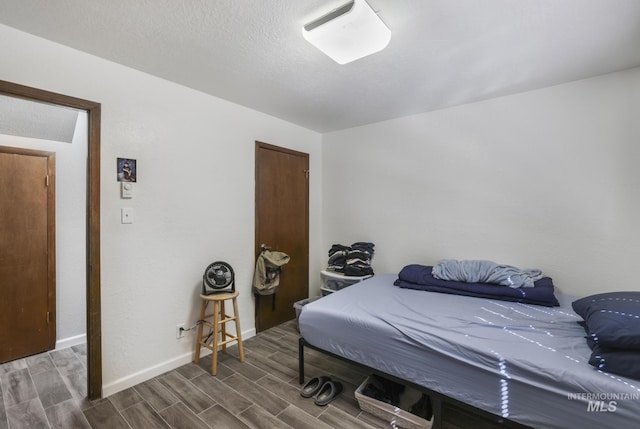 bedroom featuring baseboards and wood finish floors