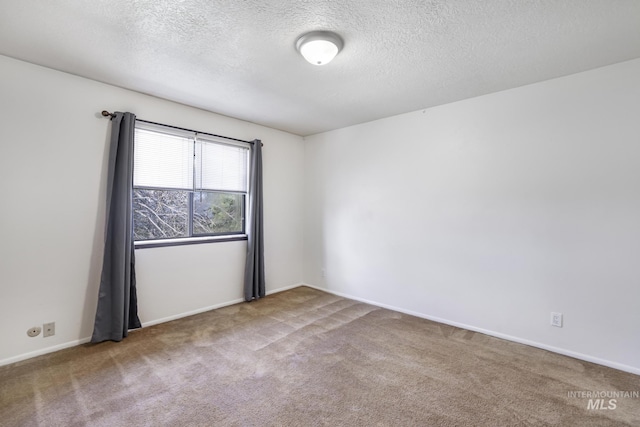 unfurnished room featuring carpet flooring, a textured ceiling, and baseboards