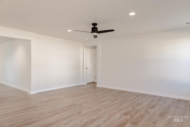 empty room with ceiling fan and light hardwood / wood-style floors