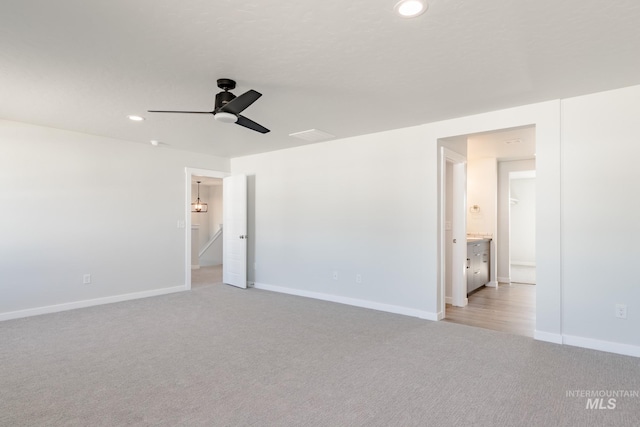 unfurnished bedroom with light colored carpet, ceiling fan, and ensuite bathroom